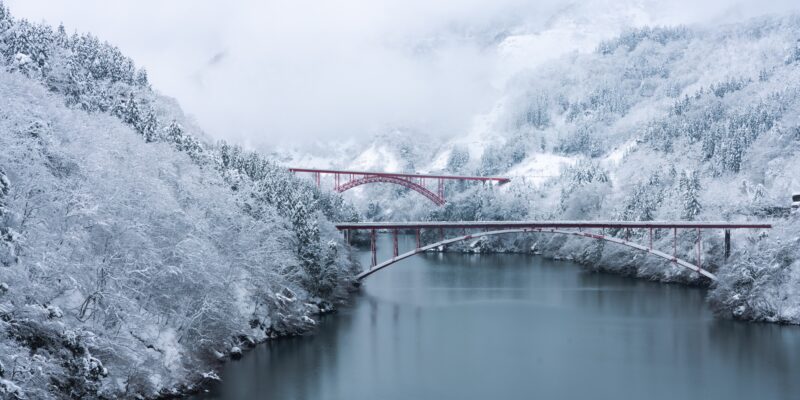 Red bridge over shokawa gorge river in toyama prefecture, japan