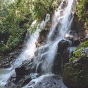 scenic view of beautiful Kanto Lampo Waterfall, green plants and rocks, Bali, Indonesia