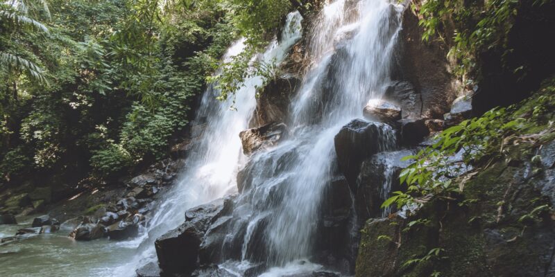 scenic view of beautiful Kanto Lampo Waterfall, green plants and rocks, Bali, Indonesia